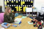 Cassie Queen helps a student with their class work