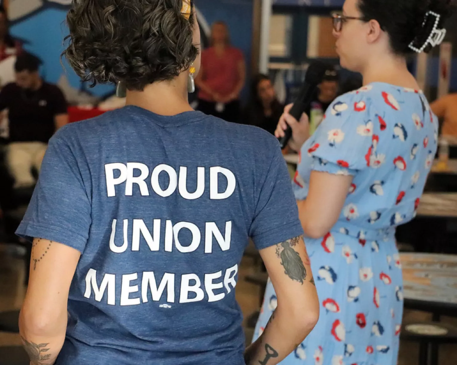 DSEA members speaking to a crowd. The back of one member's shirt says "Proud Union Member."