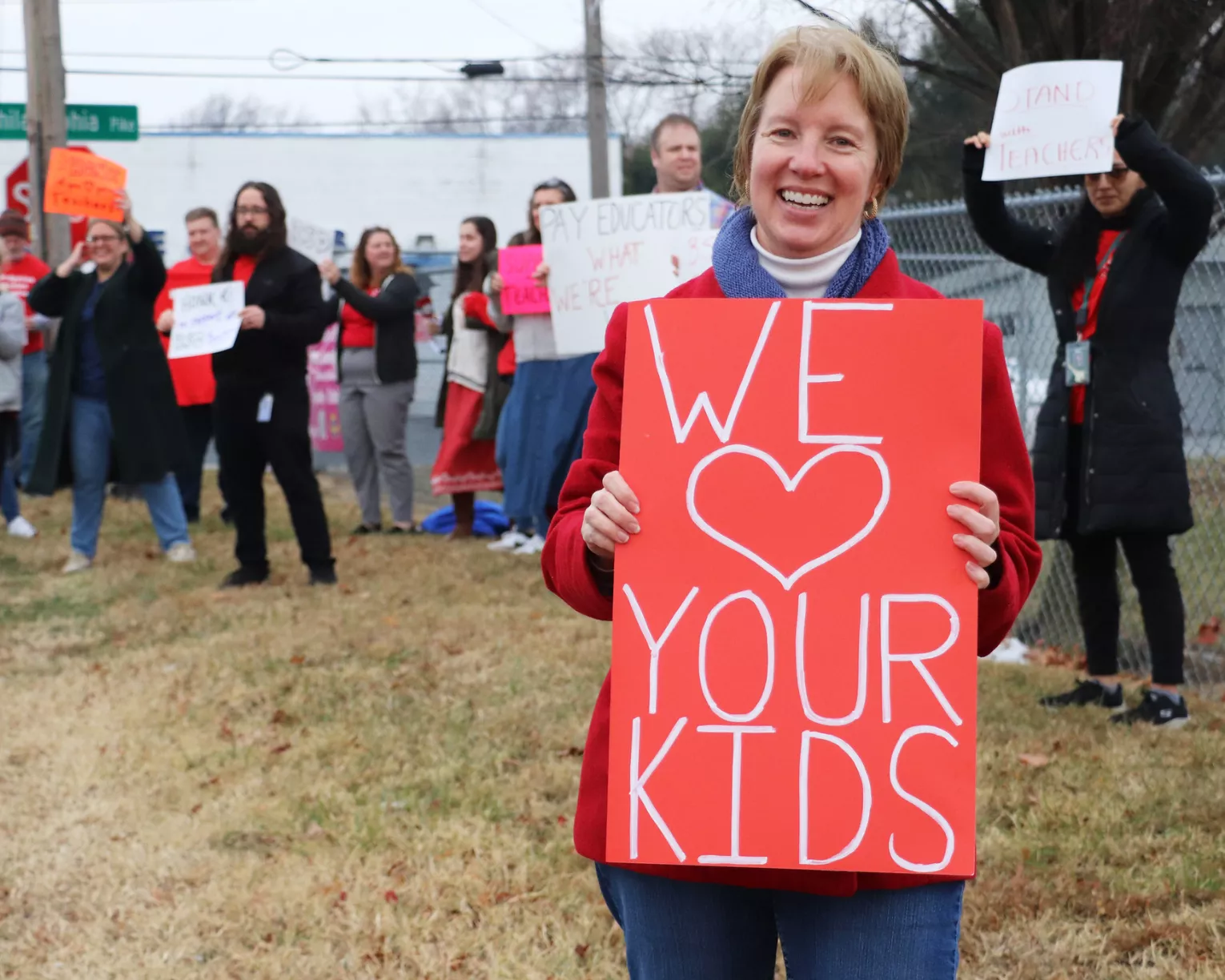 A Brandywine Education Association member at a picket with a sign that says "we <3 your kids."