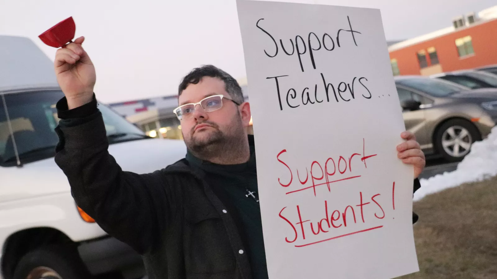 picketer with sign that says "support teachers, support students"