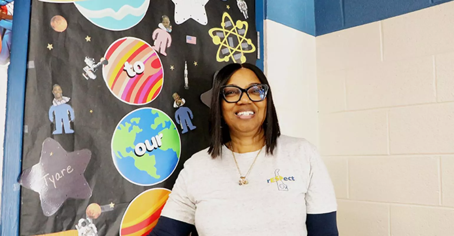Jozette Hartsfield stands in front of a classroom door