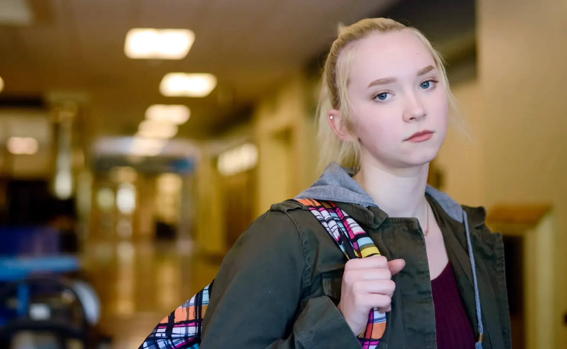 A teen girl at school looks at the camera