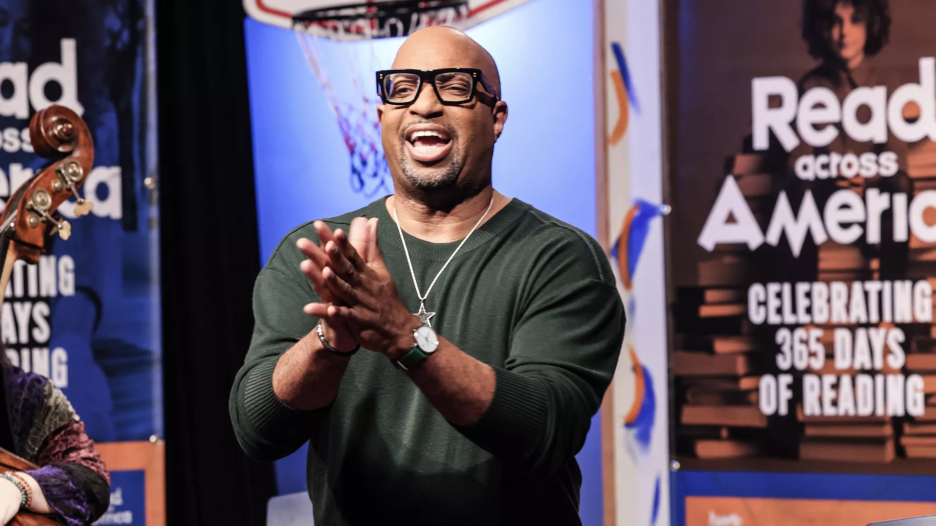 Kwame Alexander in a dark green shirt with hands clasped